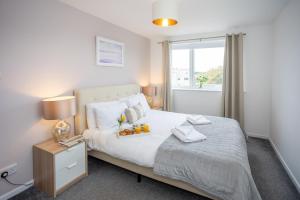 una camera da letto con un grande letto bianco e una finestra di Stunning 2 bed seaside apartment with Sea Views a Bournemouth