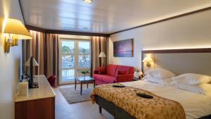a hotel room with a bed and a red chair at Naantali Spa Hotel in Naantali