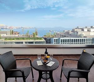 a table with two chairs and a bottle of wine on a balcony at Port Bosphorus in Istanbul