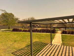 a bench with a shade in a park at CyC Guest Lodge in Giyani