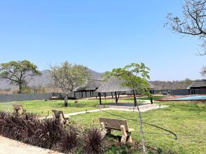 a park with benches in the grass and a building at CyC Guest Lodge in Giyani