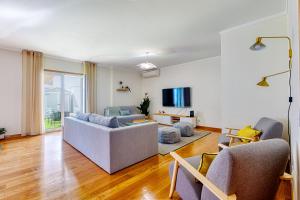 uma sala de estar com dois sofás e uma televisão em Stunning House with Terrace em Lisboa