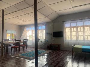 um quarto com uma mesa e cadeiras e uma sala de jantar em Warisan Homestay A em Mersing