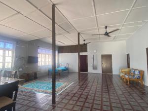 an empty room with a room with tables and chairs at Warisan Homestay A in Mersing