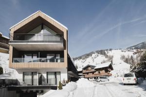a building with a balcony in the snow at Haus Jausern in Saalbach-Hinterglemm