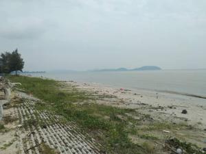 a beach with a rocky shore and the ocean at Warisan Homestay A in Mersing
