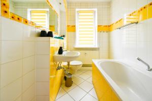 un bagno con lavandino, vasca e WC di Modernes Altmarkt Apartment mit Parkplatz 4 Gäste 55qm Waschmaschine Wlan Netflix Terrasse a Cottbus