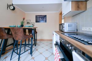 una cucina con piano di lavoro e forno a microonde di Modernes Altmarkt Apartment mit Parkplatz 4 Gäste 55qm Waschmaschine Wlan Netflix Terrasse a Cottbus