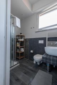a bathroom with a sink and a toilet and a window at cozy apartment in Florence