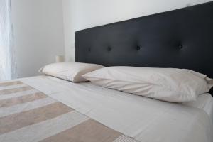 1 cama con 2 almohadas blancas y cabecero negro en cozy apartment, en Florencia