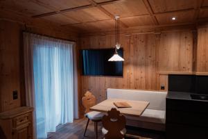 - une cuisine avec une table et un canapé dans une chambre dans l'établissement ALMA mountain residence, à Dobbiaco