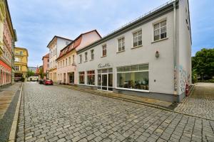 una strada acciottolata in una città con edifici di Modernes Altmarkt Apartment mit Parkplatz 4 Gäste 55qm Waschmaschine Wlan Netflix Terrasse a Cottbus Altre 5 foto