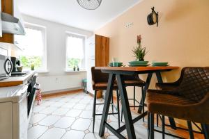 una cucina con un tavolo e sedie in una stanza di Modernes Altmarkt Apartment mit Parkplatz 4 Gäste 55qm Waschmaschine Wlan Netflix Terrasse a Cottbus