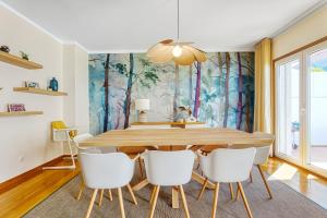 uma sala de jantar com uma mesa de madeira e cadeiras brancas em Stunning House with Terrace em Lisboa
