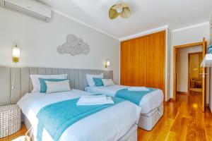 um quarto com 2 camas com lençóis azuis e brancos em Stunning House with Terrace em Lisboa