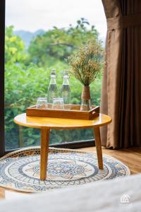 a table with glasses and a tray with flowers on it at Avatar Homestay & Coffee - Mộc Châu in Mộc Châu