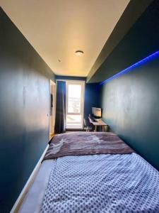 a bed in a room with a blue wall at Lovely and exclusive northern lights apartment with excellent view. in Tromsø