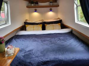 a bed in a small room in a tiny house at Cosy Canal Boat in London Centre for Family & Friends in London