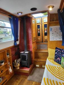 Zimmer mit einem Bett und einem Holzofen in der Unterkunft Cosy Canal Boat in London Centre for Family & Friends in London