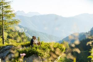 un couple assis au sommet d'une montagne dans l'établissement Posthotel Achenkirch Resort and Spa - Adults Only, à Achenkirch