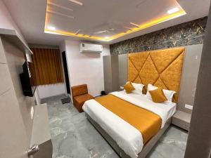 a hotel room with a bed and a chair at HOTEL KINGDOM in Gandhinagar
