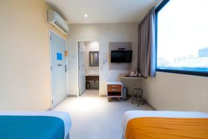 雅加達的住宿－Sans Hotel Liv Ancol by RedDoorz，酒店客房带两张床和一间浴室
