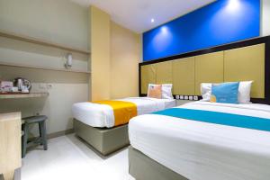 a hotel room with two beds and a counter at Sans Hotel Liv Ancol by RedDoorz in Jakarta +41 photos
