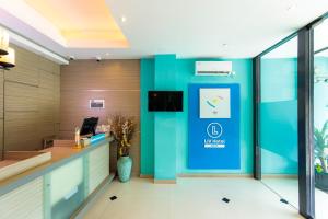 een kantoorlobby met een blauwe muur bij Sans Hotel Liv Ancol by RedDoorz in Jakarta