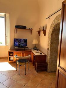 Habitación con escritorio, TV y silla. en Albori bilocale panoramico, en Vietri
