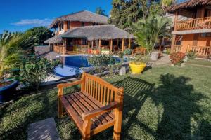 a wooden bench in the yard of a house at VILLA PANORAMA NOSY BE in Nosy Be