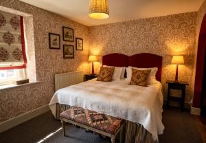 a bedroom with a bed and two lamps and a window at George and Dragon Clifton in Penrith