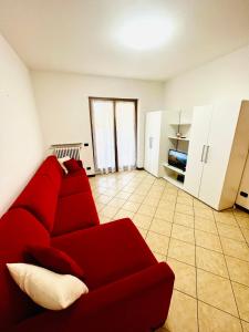 a living room with a red couch and a kitchen at Bellavista Bobbio in Bobbio