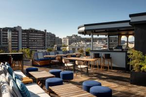 a rooftop patio with tables and chairs on a building at Le Parchamp, a Tribute Portfolio Hotel, Paris Boulogne in Boulogne-Billancourt