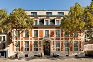 ブローニュ・ビヤンクールにあるLe Parchamp, a Tribute Portfolio Hotel, Paris Boulogneの木の入ったドアのあるアパートメントビル