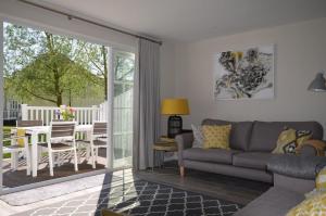 a living room with a couch and a table at Elouera, 21 Isis Lake in South Cerney