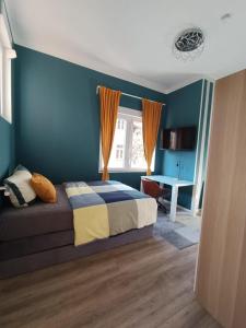 Schlafzimmer mit blauen Wänden, einem Bett und einem Schreibtisch in der Unterkunft Ressel Mansion in Bitterfeld
