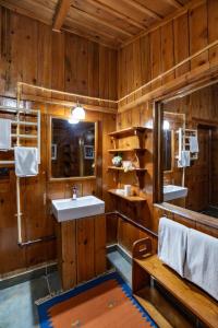 ムスーリーにあるLohonoStays Avalon 5 Bedroom Villaの木製の壁のバスルーム(シンク、ベンチ付)