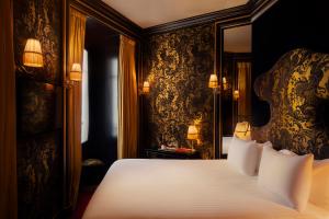 a bedroom with a large bed with a large headboard at Maison Souquet, Hotel & Spa in Paris