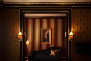 un salon avec une chaise et un tableau mural dans l'établissement Maison Souquet, Hotel & Spa, à Paris