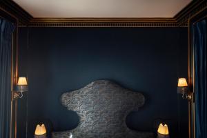 a bedroom with blue walls and a bed with two lamps at Maison Souquet, Hotel & Spa in Paris