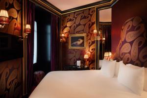 a bedroom with a bed and a mirror at Maison Souquet, Hotel & Spa in Paris