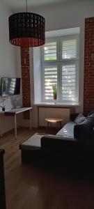 ein Wohnzimmer mit einem Sofa, einem Tisch und einem Fenster in der Unterkunft Krowoderska Center 2 in Krakau