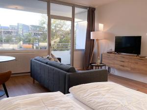 uma sala de estar com um sofá e uma televisão em Central Apartment Rhein Neuss-Düsseldorf Messe em Neuss