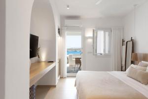 een slaapkamer met een bed en uitzicht op de oceaan bij KAMEO, Antiparos in Andiparos