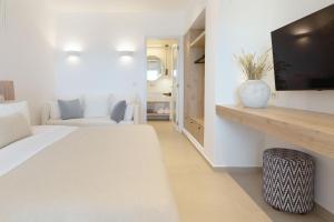a white room with a bed and a tv at KAMEO, Antiparos in Antiparos