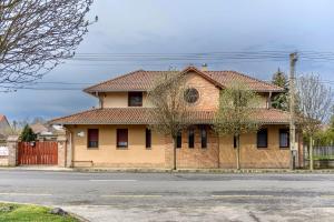 a brick house on the side of a street at Cherry Apartmanház in Sárvár