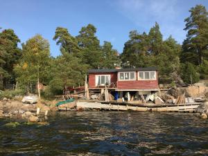 a house on a dock on a body of water at Sjöstuga, Archipelago Beach House in Värmdö