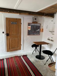 een kamer met een tafel, een deur en een tapijt bij Timberframe house near Marstal Harbour in Marstal