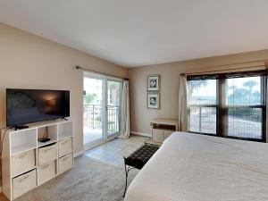 a bedroom with a bed and a flat screen tv at Emerald Isle fort Walton Beach 209 in Fort Walton Beach
