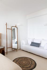 a living room with a white couch and a mirror at KAMEO, Antiparos in Antiparos